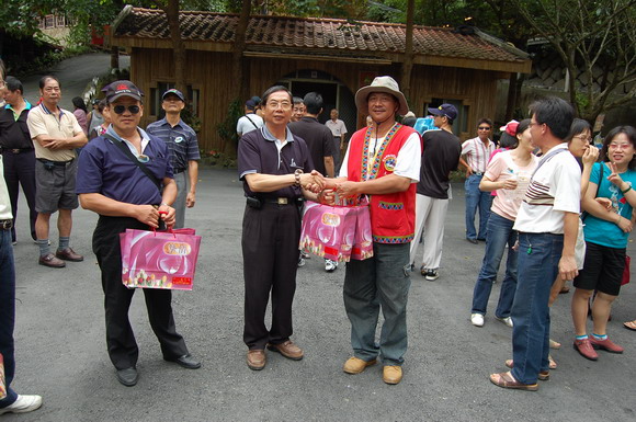 理事長致贈禮物，由嘉義達賴伊谷楊主任代表山美社區發展協會理事長接受禮物。