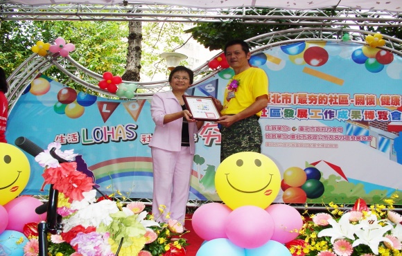 本社區榮獲第二類組績優社區，陳理事長接受社會局師局長頒發證書。
