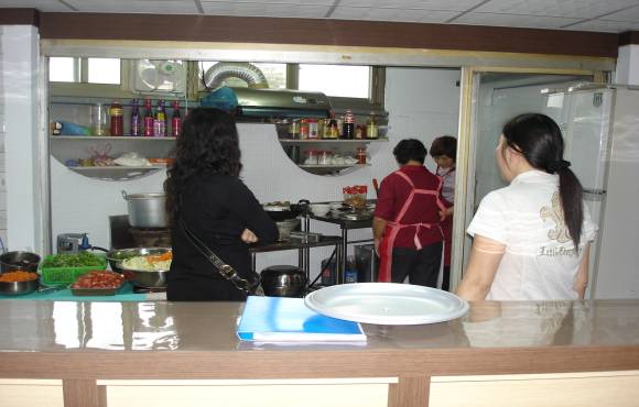 廚房阿姨們專心研究如何做出美味大餐，好讓來電顧客享受美食。